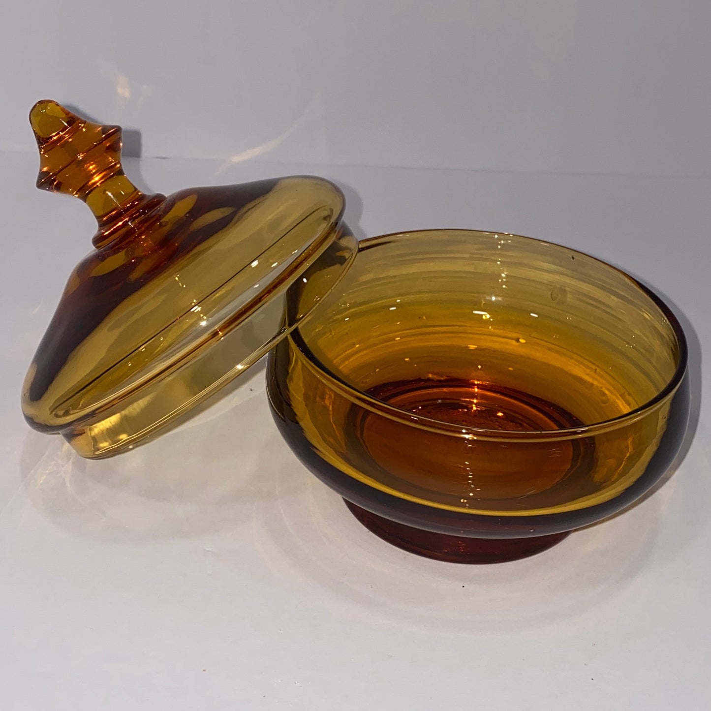 Amber-colored glass candy compte on a white background